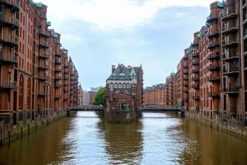 Rødbrune murbygninger på hver side av en kanal.