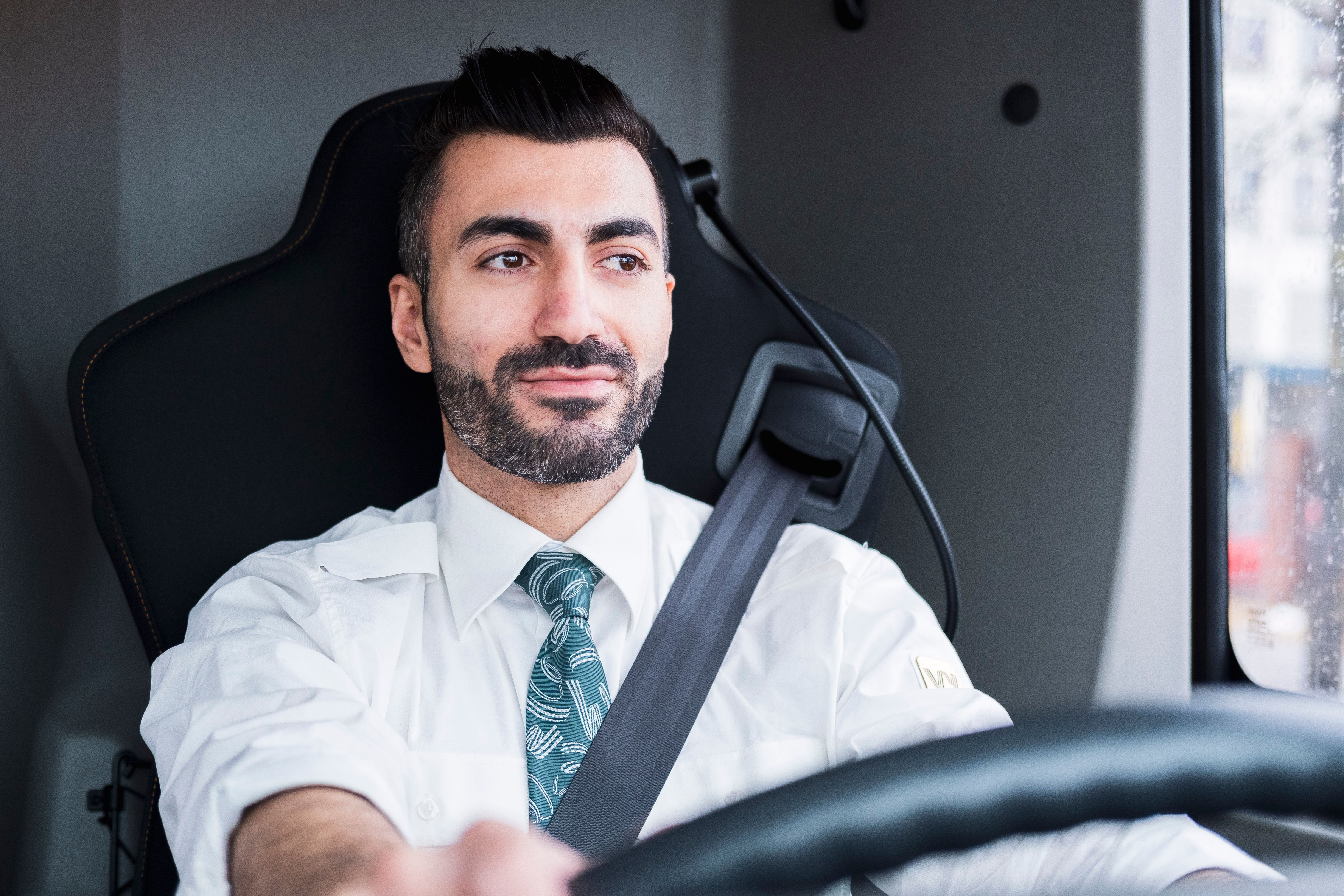 Bussjåfør kjører bussen og ser på veien