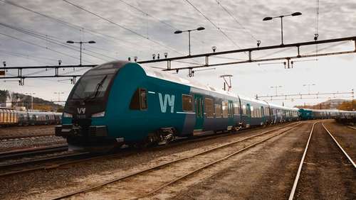 A green train on the tracks.