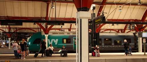 Vy-tog på Malmö stasjon, med passasjerar som ventar.