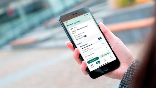 En hånd som holder en mobil med Smartpris på skjermen