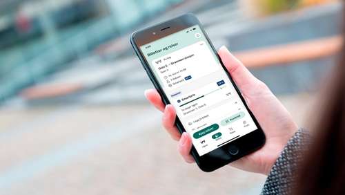 En hånd som holder en mobil med Smartpris på skjermen