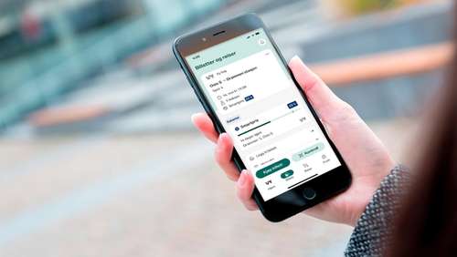 En hånd som holder en mobil hvor skjermen viser Smartpris i Vy-appen