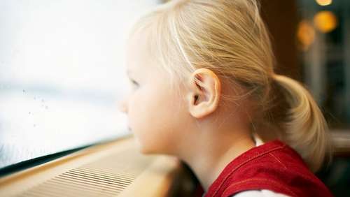 En liten jente på toget som ved vinduskarmen, og ser ut av togvinduet