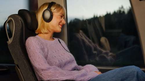 Fornøyd ung kvinne sitter i et buss-sete