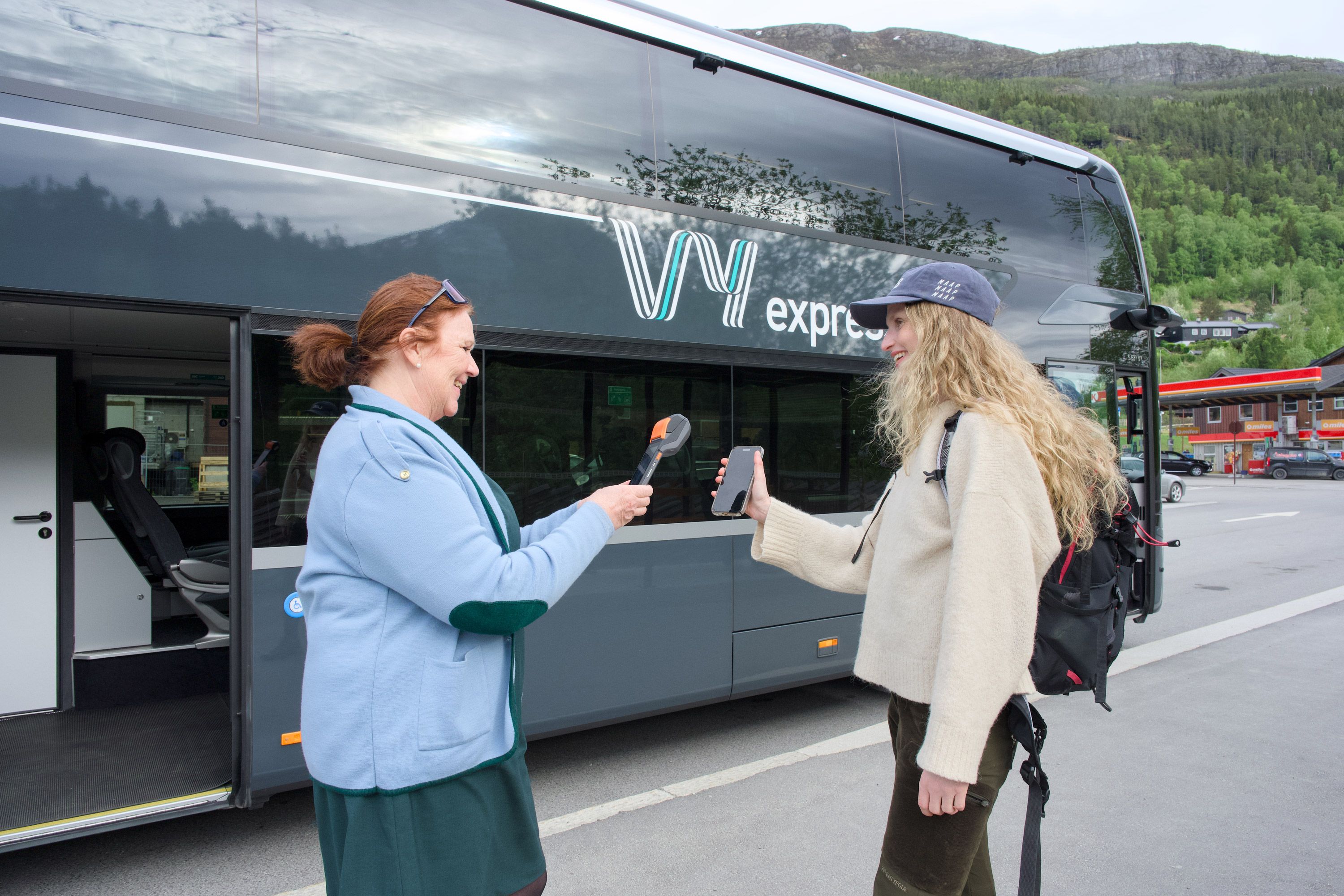 En bussjåfør fra Vy som skanner billetten til en kunde.