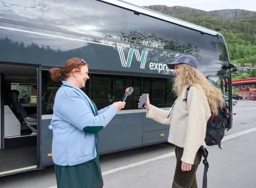 En bussjåfør fra Vy som skanner billetten til en kunde.