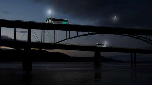 Two Vy buses driving over two different bridges at night.