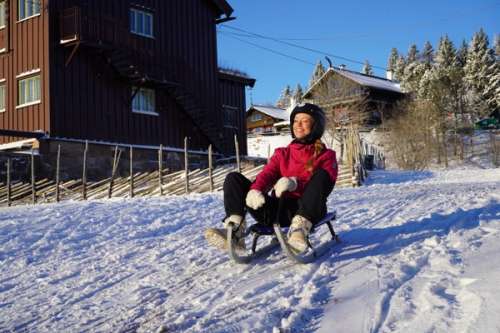 Flicka åker kjälke i snö