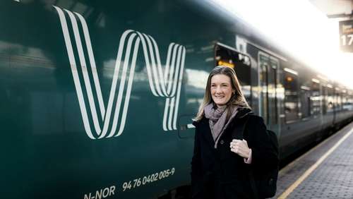 Kvinne står utenfor et tåg