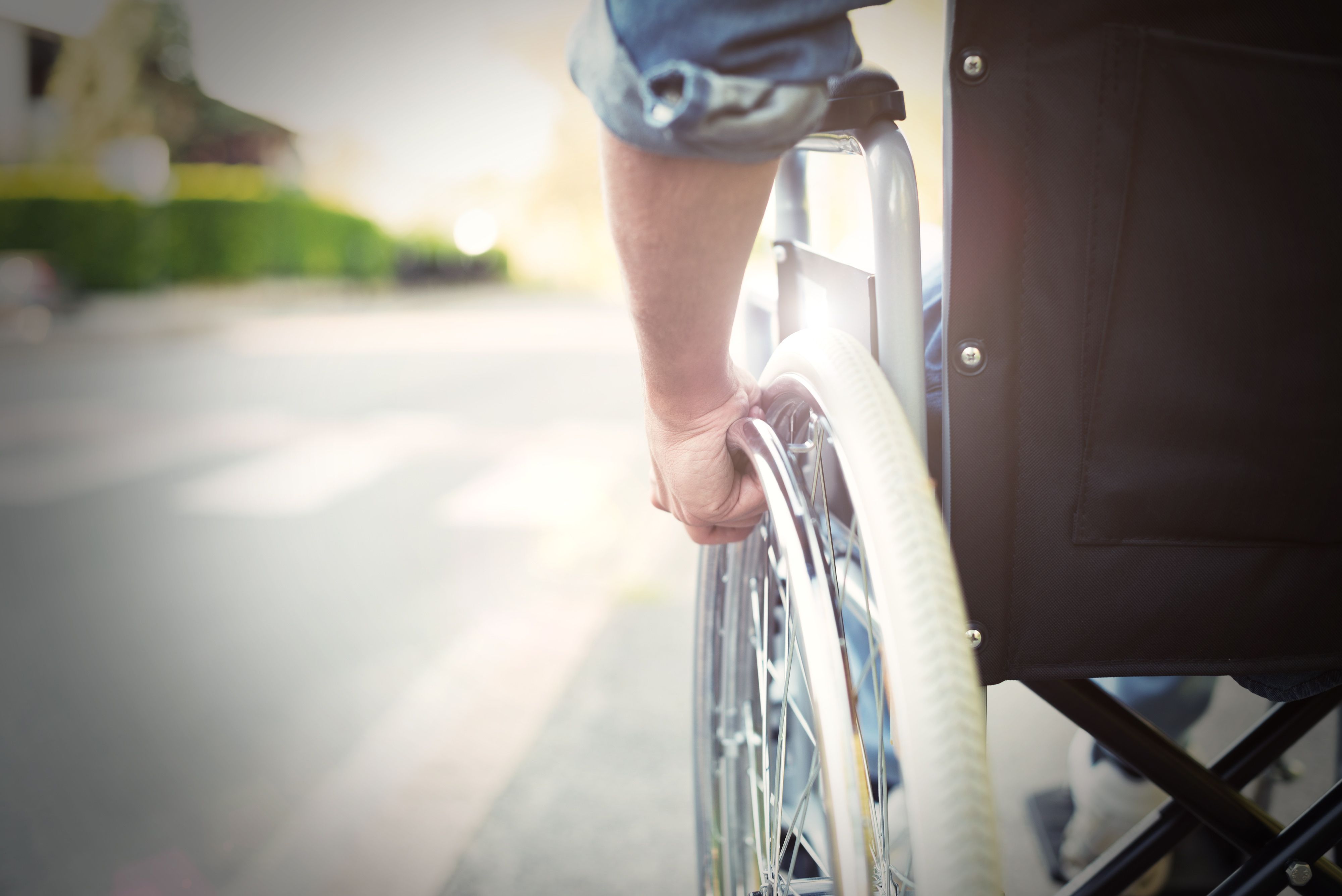 Close-up of wheelchair wheel with the user's hand on the wheel