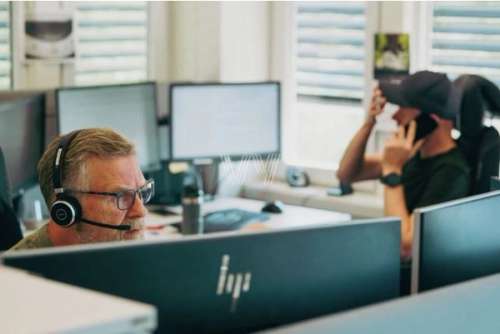 Två män på kontor som sitter vid datorn och jobbar
