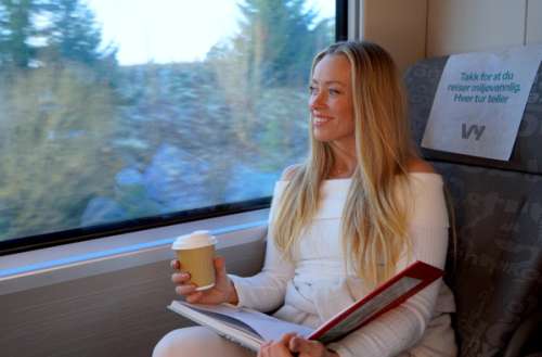 Merete på Vy tåg med kaffe i handen