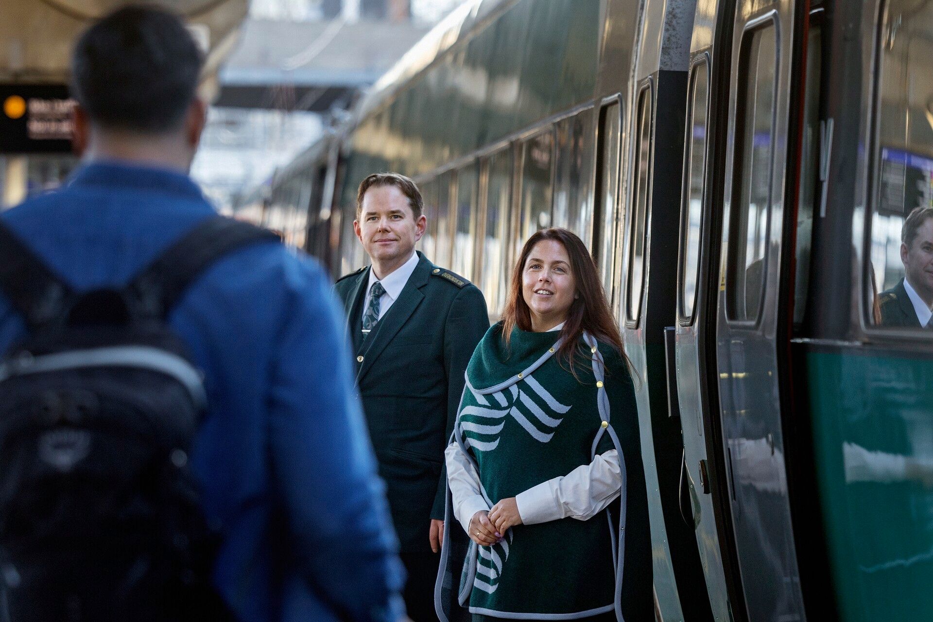 Conductor helps customer on the platform