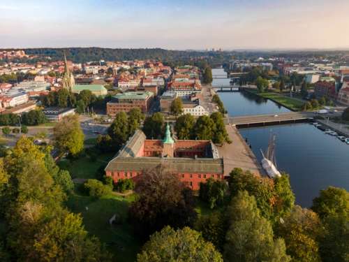 Halmstad slott i drönarperspektiv med utsikt över staden en sommarkväll