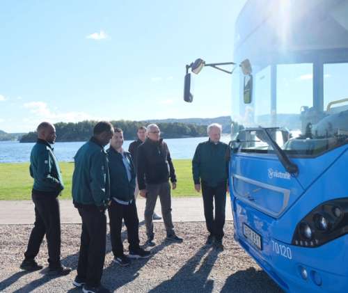En grupp förare från Vy utanför en blå buss