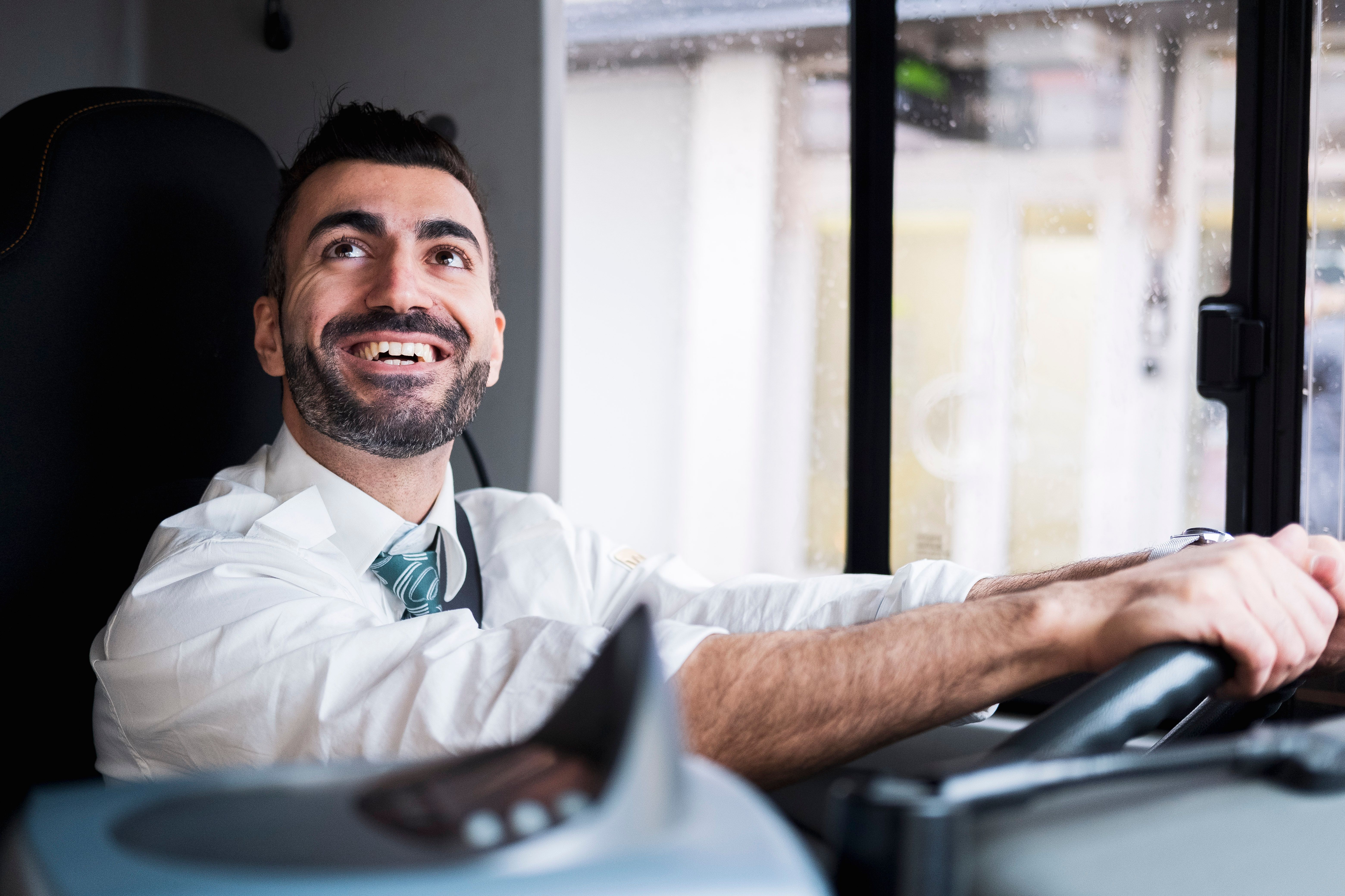 Gladlynt busschaufför vid ratten