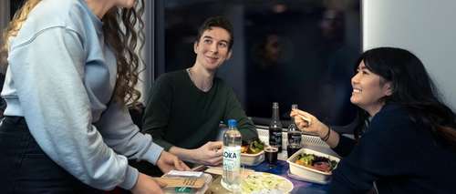 Tre vänner äter middag på ett tåg och samtalar