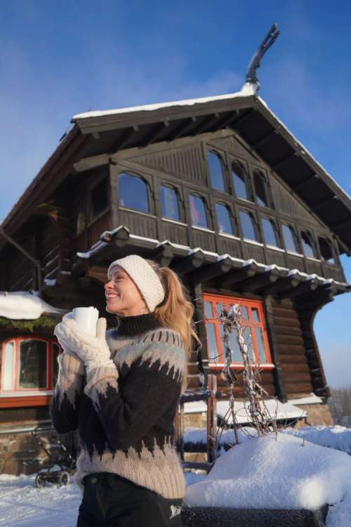 Merete vid en träbyggnad