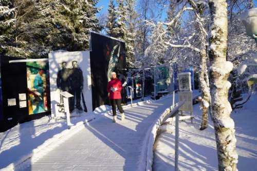 Flicka i vinterlandskap med skidor i handen